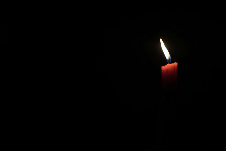 Candle illuminating light in dark room