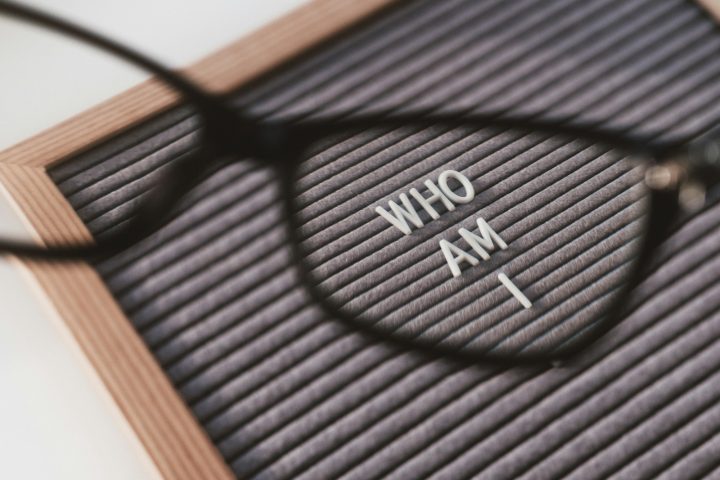 Top view on letterboard with words WHO AM I through eyeglasses.Social psychological issue