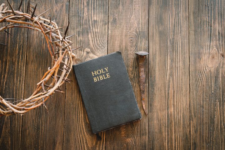 Crown thorns and holy bible or book on a wood background