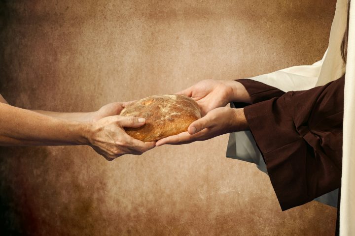 Jesus gives the bread to a beggar.