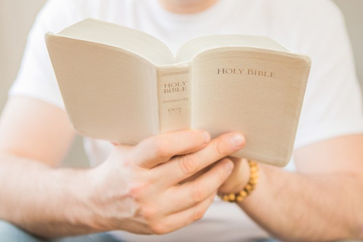 The Christian holds the Bible. Reading the bible. The concept of faith, spirituality and religion